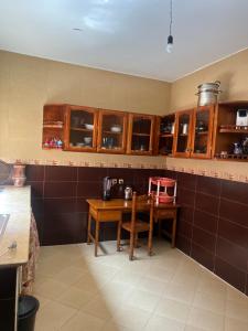 a kitchen with a wooden table and brown cabinets at Hrich house in Fnidek +2 photos