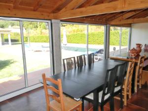 a dining room with a black table and chairs at Welcoming villa in Santa Leocádia, private pool 475 m² in Feijoal