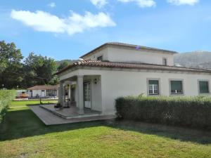 a white house with a grass yard in front of it at Welcoming villa in Santa Leocádia, private pool 475 m² in Feijoal