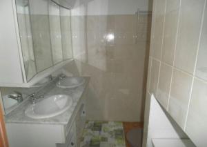 a bathroom with two sinks and a mirror at Appartement moderne à Schoelcher avec terrasse et vue mer in Schœlcher