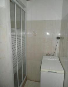a white bathroom with a toilet and a shower at Appartement moderne à Schoelcher avec terrasse et vue mer in Schœlcher