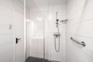 a bathroom with a shower and a sink at Strandhuys Oester in De Koog +11 photos