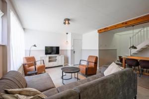 a living room with a couch and a tv at Strandhuys Oester in De Koog
