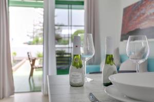 two bottles of wine sitting on a table with glasses at Charming apartment in Tías with shared pool - 50 m² in Tías