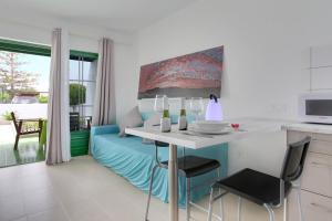 a kitchen and living room with a table and a couch at Charming apartment in Tías with shared pool - 50 m² in Tías