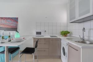 a white kitchen with a sink and a washing machine at Charming apartment in Tías with shared pool - 50 m² in Tías +14 photos