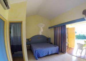 a bedroom with a blue bed and a balcony at Studio confortable à Sainte-Anne - 30 m² avec vue mer in Sainte-Anne