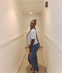 a young girl standing in a room with a wall at Kalis Hotel in Douala