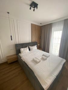 a bedroom with a large bed with white sheets and pillows at Apartamente Arad Premium in Arad