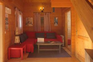 a living room with a red couch and a table at Charming bungalow in Tarifa with mountain view and garden in Tarifa