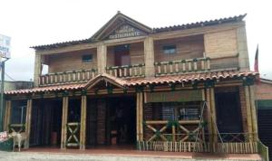 a wooden building with a dog standing in front of it at Hospedaje Los Tumbilos in Silos