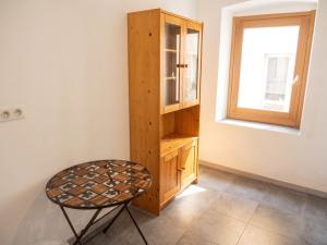 a chair in a room with a cabinet and a window at Appartement cosy à Bonifacio avec vue sur la mer - 45 m² in Bonifacio