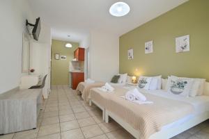 a hotel room with two beds and a bathroom at Harikleia Studios in Leptokarya