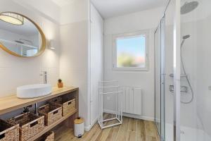 a white bathroom with a sink and a mirror at L'Epine Bleue in LʼÉpine +25 photos