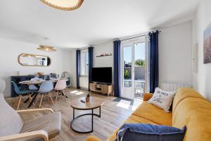 a living room with a couch and a table at L'Epine Bleue in LʼÉpine
