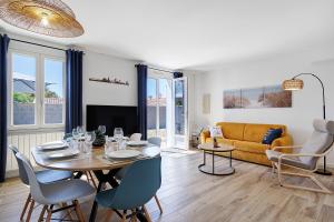 a living room with a table and chairs and a couch at L'Epine Bleue in LʼÉpine