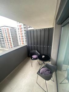 a balcony with two chairs and a table and a window at Apartamente Arad Premium in Arad