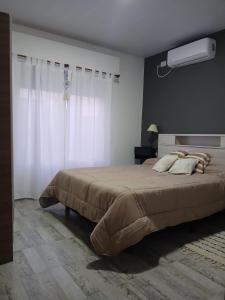 a bedroom with a large bed and a window at Los Aromos Carhue in Carhué
