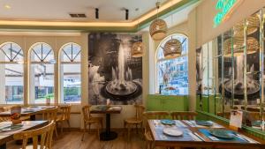 a restaurant with tables and chairs and windows at Hostal Costa Coruña in A Coruña +31 photos