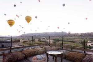 a balcony with hot air balloons flying in the sky at Unique Cappadocia Palace in Göreme +88 photos