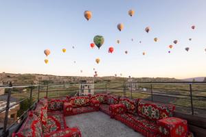 a bunch of hot air balloons flying in the sky at Unique Cappadocia Palace in Göreme