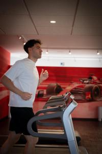 a man running on a treadmill in a gym at Maranello Palace in Maranello