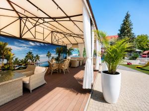 a patio with a table and chairs and an umbrella at Hotel SPA Faltom Gdynia Rumia in Rumia