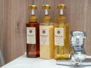three bottles of oil sitting on a shelf with at Hotel Global View Nagaoka in Nagaoka