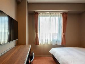 a bedroom with a bed and a window at Hotel Global View Nagaoka in Nagaoka