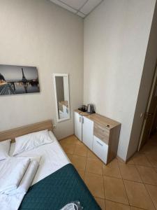 ein Schlafzimmer mit einem Bett und einem Schreibtisch mit Spiegel in der Unterkunft Mini hotel Non-Stop in Kiew