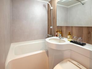 a bathroom with a sink and a toilet and a tub at Hotel Global View Nagaoka in Nagaoka +29 photos