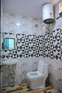 a bathroom with a white toilet and a sink at Hotel New Residency Ayodhya in Ayodhya