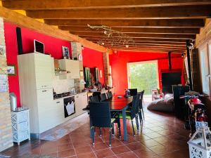 a kitchen with red walls and a table and chairs at Cascina Rocchino bed and breakfast in Predosa