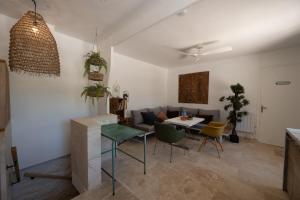 a kitchen and living room with a table and chairs at Maison Henriette - Authentique maison ardéchoise in Labeaume