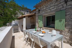 a white table and chairs on a patio at Maison Henriette - Authentique maison ardéchoise in Labeaume