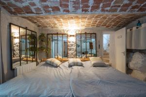 a bedroom with a large bed with pillows on it at Maison Henriette - Authentique maison ardéchoise in Labeaume