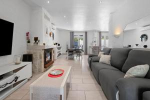 a living room with a gray couch and a table at Villa Hacienda piscine et terrasse in Vidauban