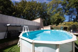 a large swimming pool in a yard with an umbrella at Villa Hacienda piscine et terrasse in Vidauban