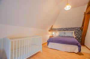 a bedroom with a bed and a crib at Chez annie in Onjon