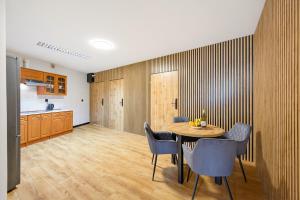 a kitchen and a dining room with a table and chairs at Apartamenty Centrum in Rybnik