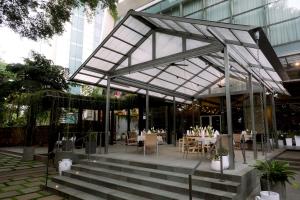 a restaurant with tables and chairs in front of a building at Hilton Bandung in Bandung