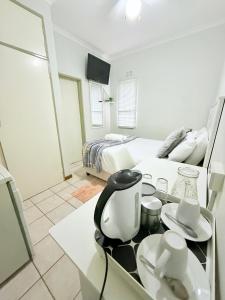 a room with a bed and a table with a tea kettle at Paradise Corner in Francistown