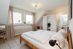 a bedroom with a large white bed in a room at Sonneneck in Westerland