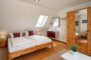 a bedroom with a wooden bed and a bathroom at Sonneneck in Westerland