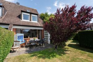 a house with a table and chairs in the yard at Sonneneck in Westerland