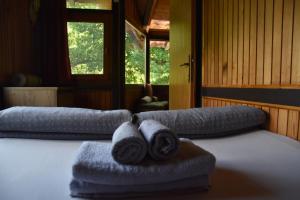 two towels on a bed in a room with windows at ECO cabin Plivsko jezero Jajce in Jajce