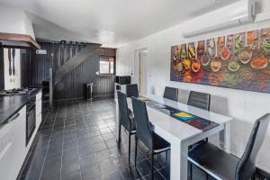 a kitchen with a table and chairs and a painting on the wall at Gite grande capacité en Puisaye in Breteau