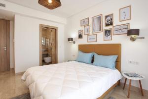 a bedroom with a large white bed with blue pillows at La Brise De Gammarth in Gammarth