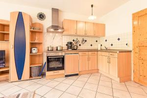 a large kitchen with wooden cabinets and a blue surfboard at Wiesenglück in Abtsgmünd
