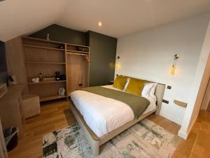 a bedroom with a large bed with yellow pillows at Auberge Hotel by Sasco in Lytham St Annes